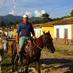 Trinidad, Kuba. Typische Szene: Reiter vor der Kulisse bunter alter Häuser.