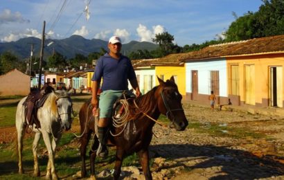 Trinidad, Kuba. Typische Szene: Reiter vor der Kulisse bunter alter Häuser.