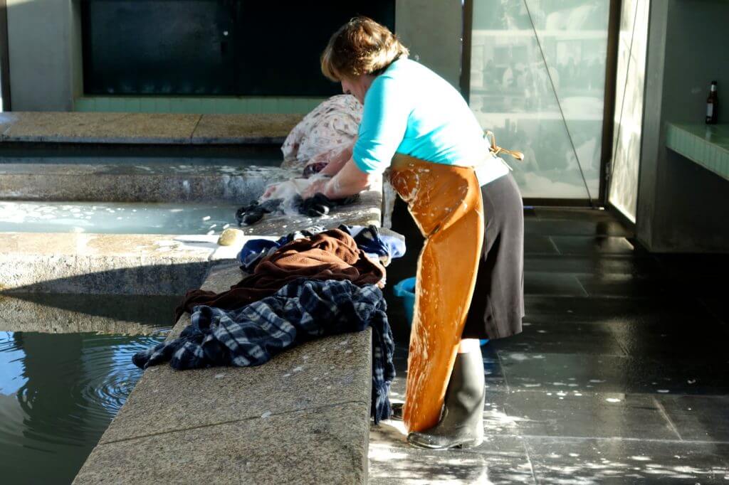 Frau bei der Arbeit im Lavadouro Público, dem öffentlichen Waschhaus von Afurada