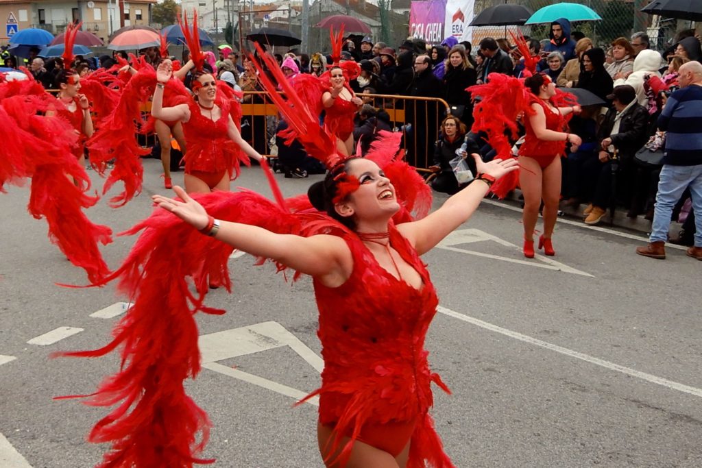 Karneval in Ovar, Portugal. Tänzerinnen in Rot trotzen dem Regen.