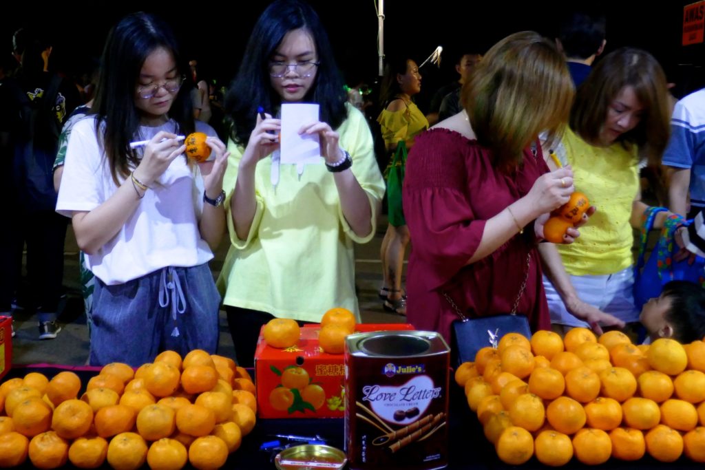 Chap Goh Meh, chinesischer Valentinstag in George Town, Malaysia. Sorgfältig werden die Früchte vor dem Werfen beschriftet.