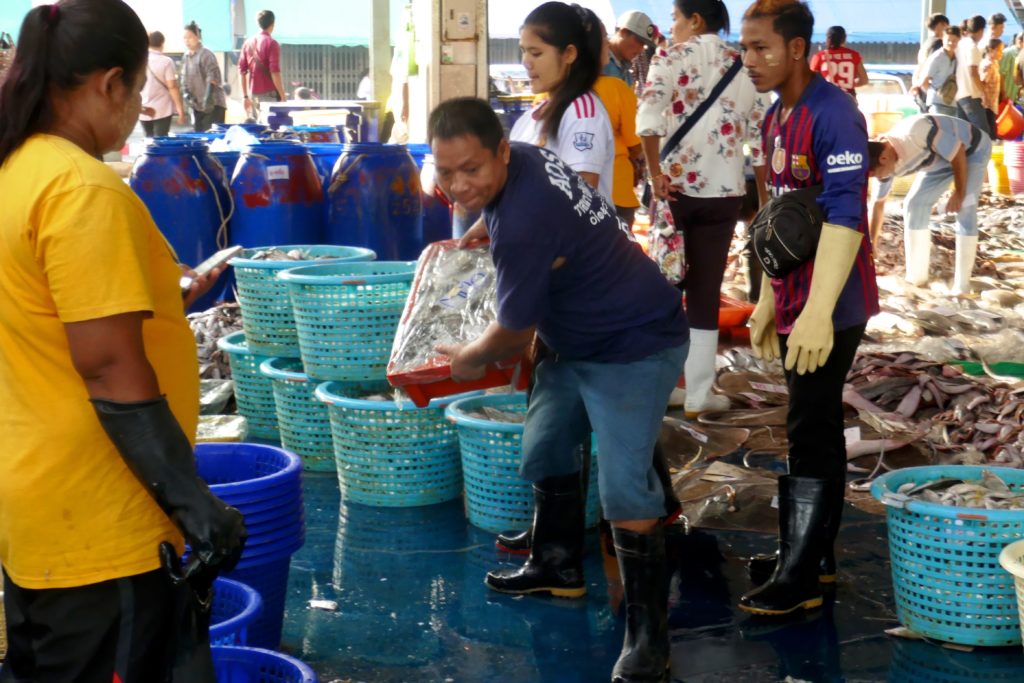 Kisten fliegen auf dem Fischmarkt von Ranong.