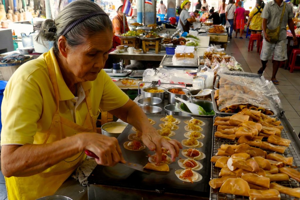 Menschen in Ranong. Zubereitung knuspriger Pfannkuchen auf dem Muang Ranong Municipal Food Market.