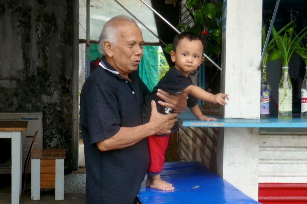 Menschen in Ranong. Opa und Enkel auf der Straße.