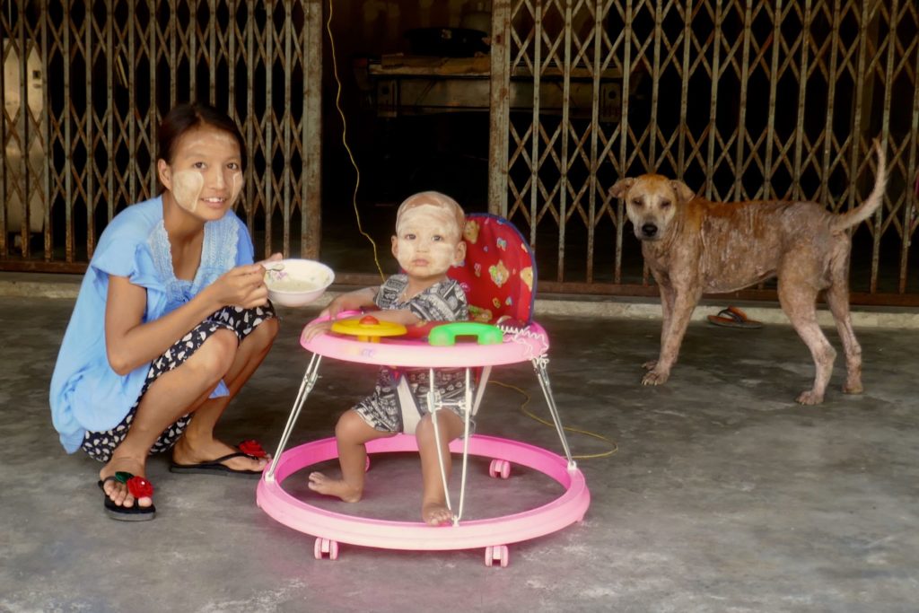 Menschen in Ranong. Babyfütterung mit Hund.
