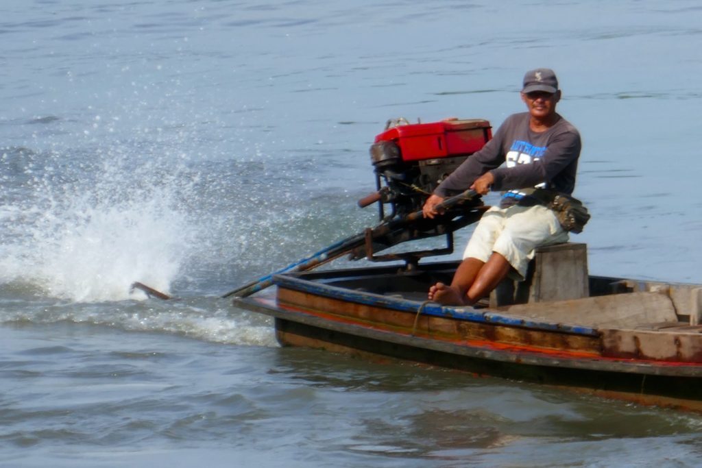 Menschen in Ranong. Motorboot im Hafen von Ranong.
