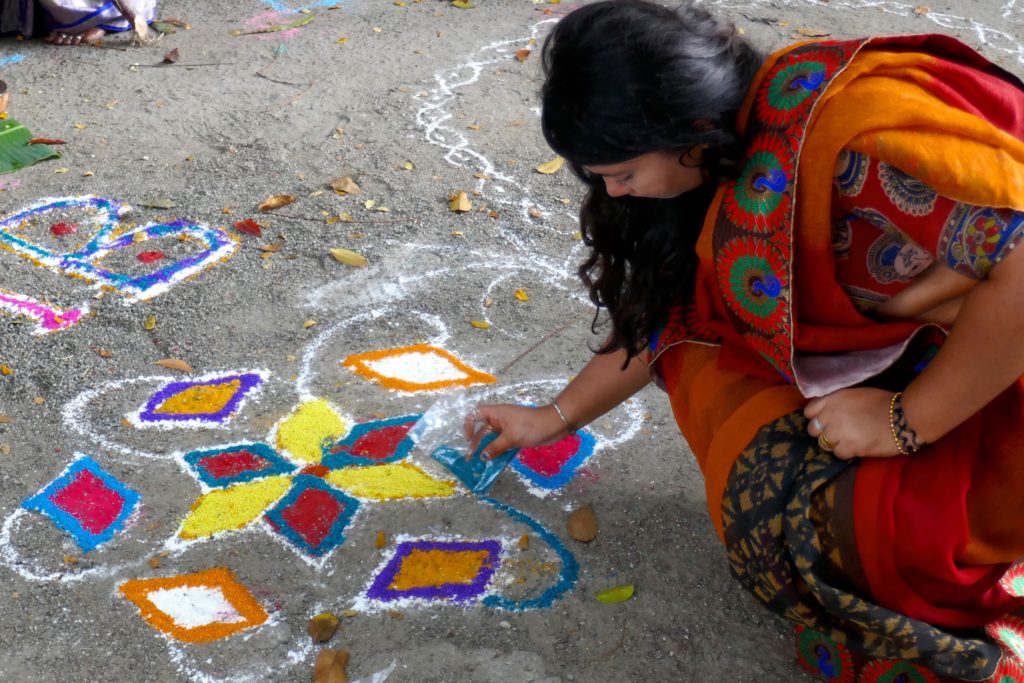 Pongal in George Town, Malaysia. Frau beim Zeichnen eines Kolams.