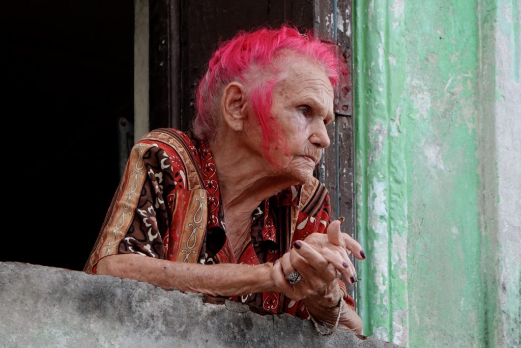 Alte Frau mit roten Haaren in der Altstadt von Havanna.