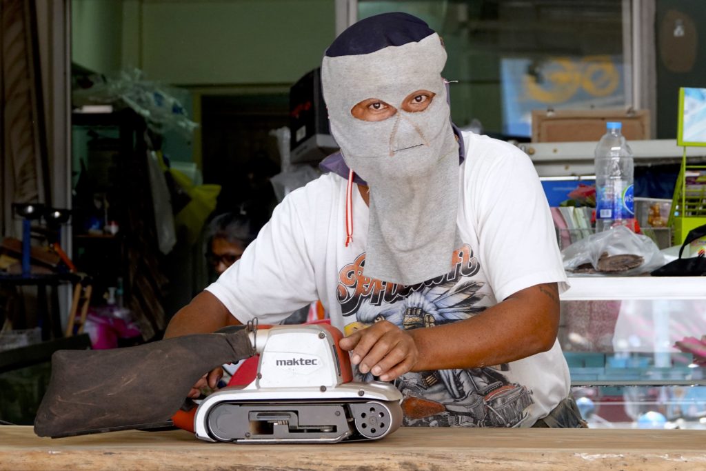 Mann mit Gesichtsmaske bei der Arbeit in Hua Hin.