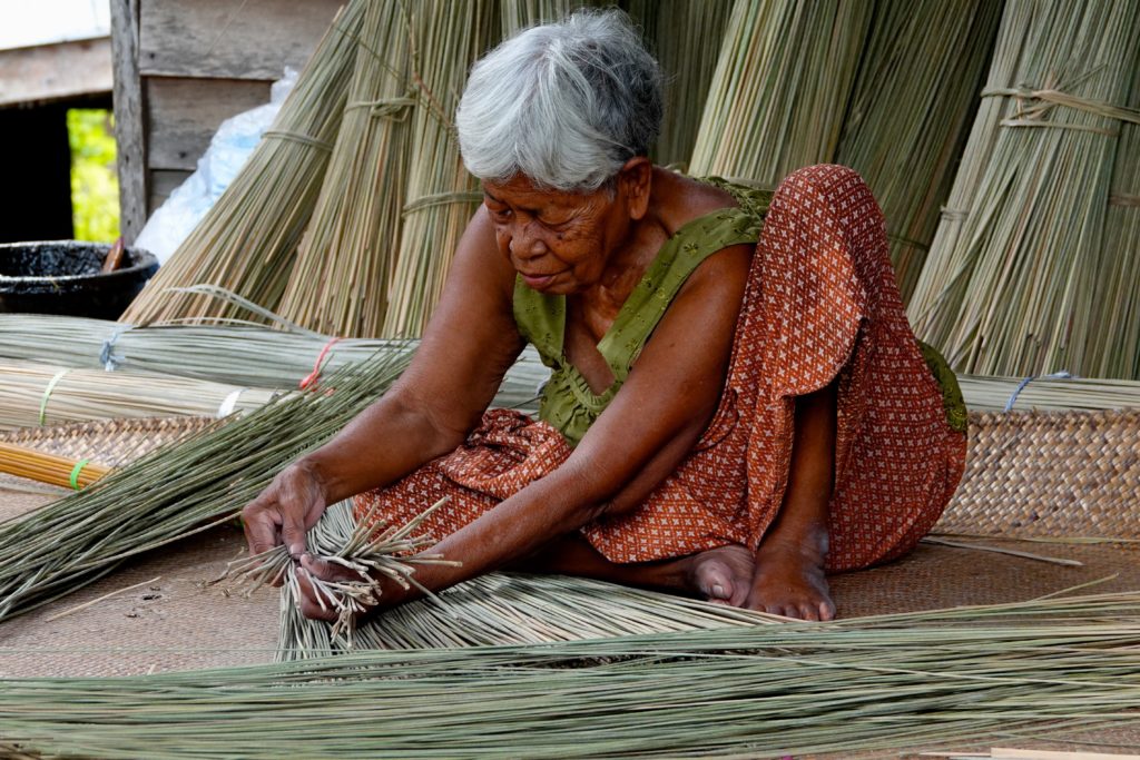 Traditionelles Kunsthandwerk in Ban Thale Noi: Verarbeitung von Gräsern der Krajood-Pflanze.