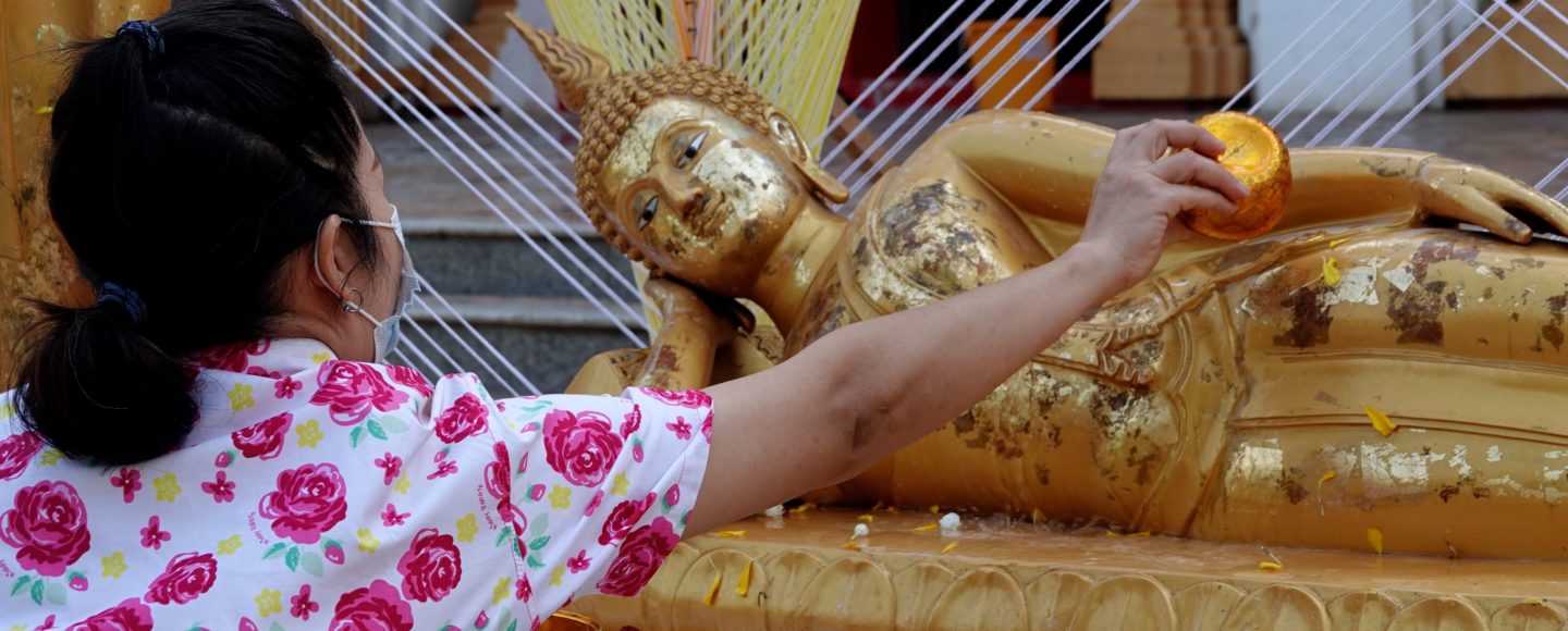 Songkran in Khon Kaen. Buddha-Figur wird im Tempel Phra Mahathat Kaen Nakhon mit Wasser übergossen.