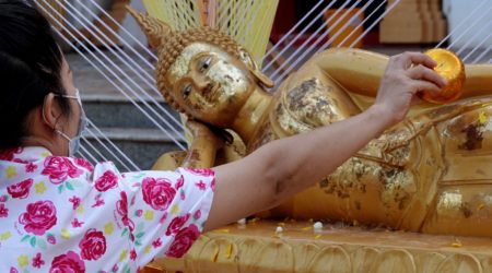 Songkran in Khon Kaen. Buddha-Figur wird im Tempel Phra Mahathat Kaen Nakhon mit Wasser übergossen.