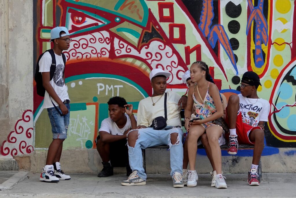 Coole Kids in Havanna vor Graffiti-Kulisse.