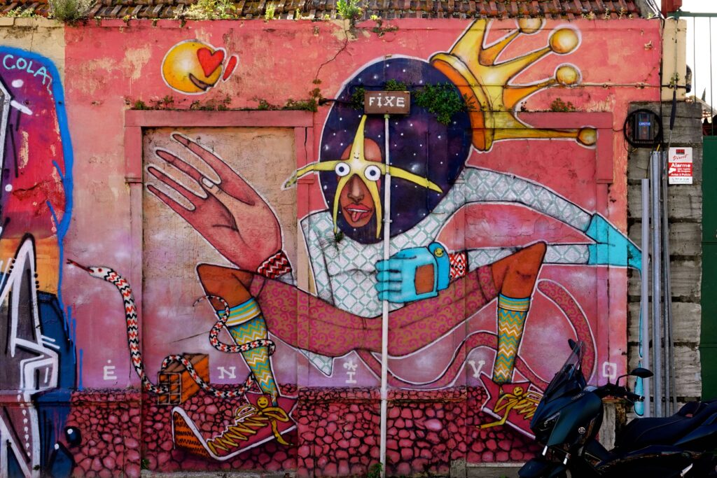 Farbenfrohes Mural mit maskierter Figur und Krone von Enivo beim Cor de Chelas Festival