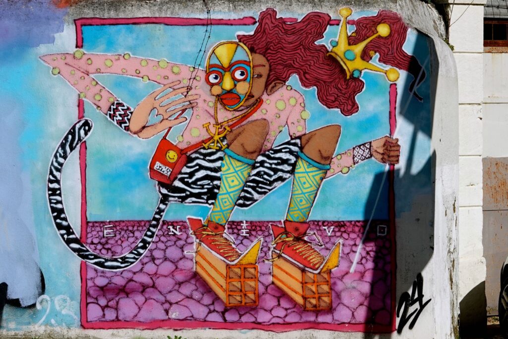 Bunte maskierte Figur von Künstler Enivo beim Cor de Chelas Street-Art-Festival
