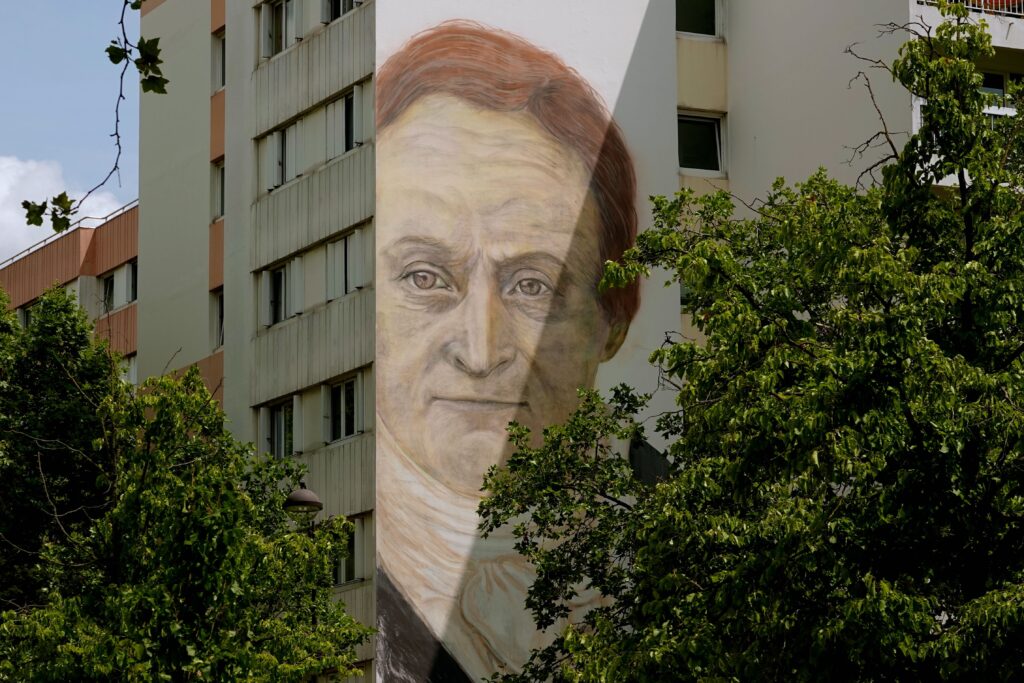 Realistisches Porträt von Philippe Pinel vom Künstler Jorge Rodriguez-Gerada an einer Hochhausfassade am Place Pinel in Paris 13