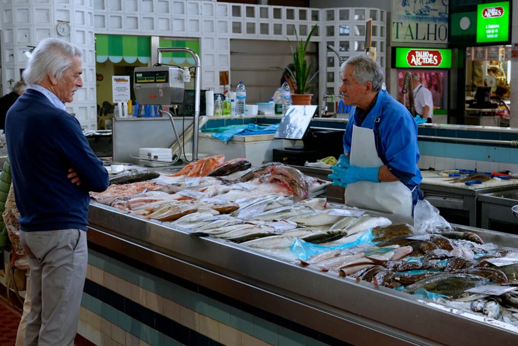 Fischstand mit Verkäufer und Kunde im Alvalade-Markt in Lissabon